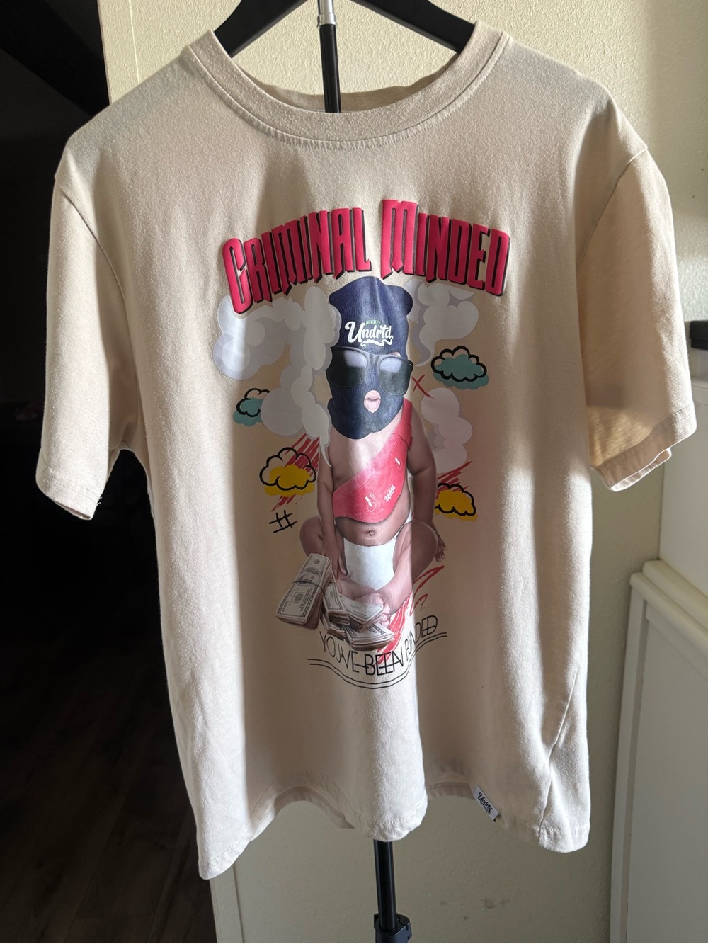 Undefeated Cream Short-Sleeve Graphic Tee with Pink Accents